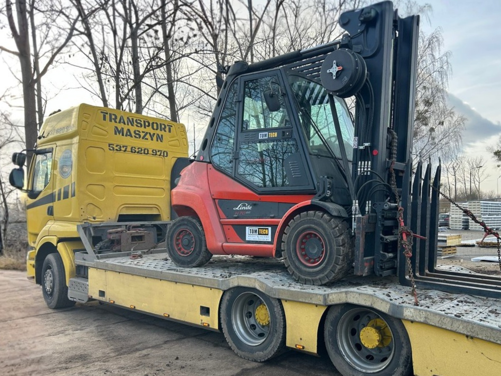 Transport wózka widłowego lawetą do przewozu maszyn przemysłowych.
