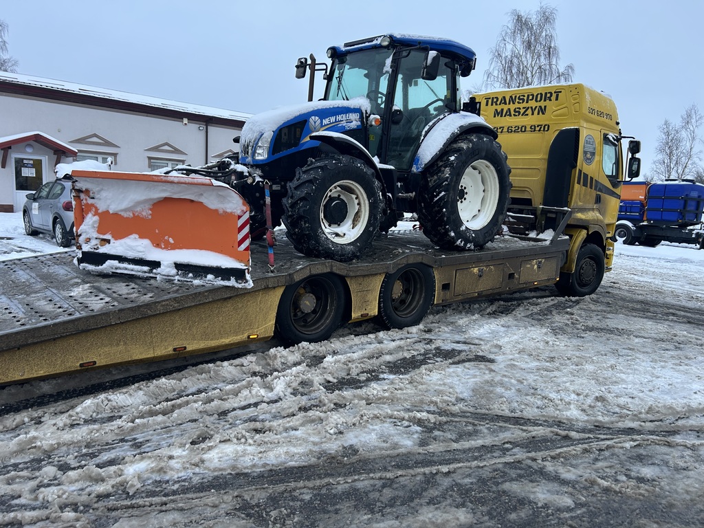 Transport traktora rolniczego lawetą zimą na terenie Polski.