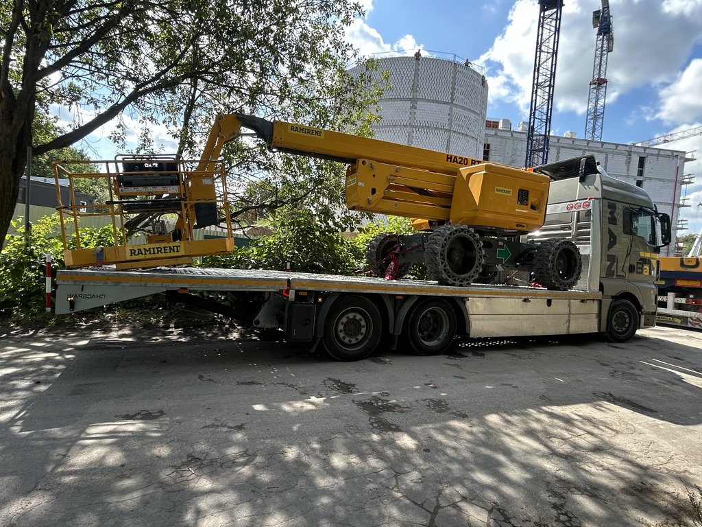 Transport dużej maszyny budowlanej na specjalistycznej lawecie ciężarowej.