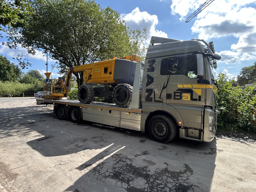 Transport maszyny z wysięgnikiem na lawecie niskopodwoziowej w Koszalinie.